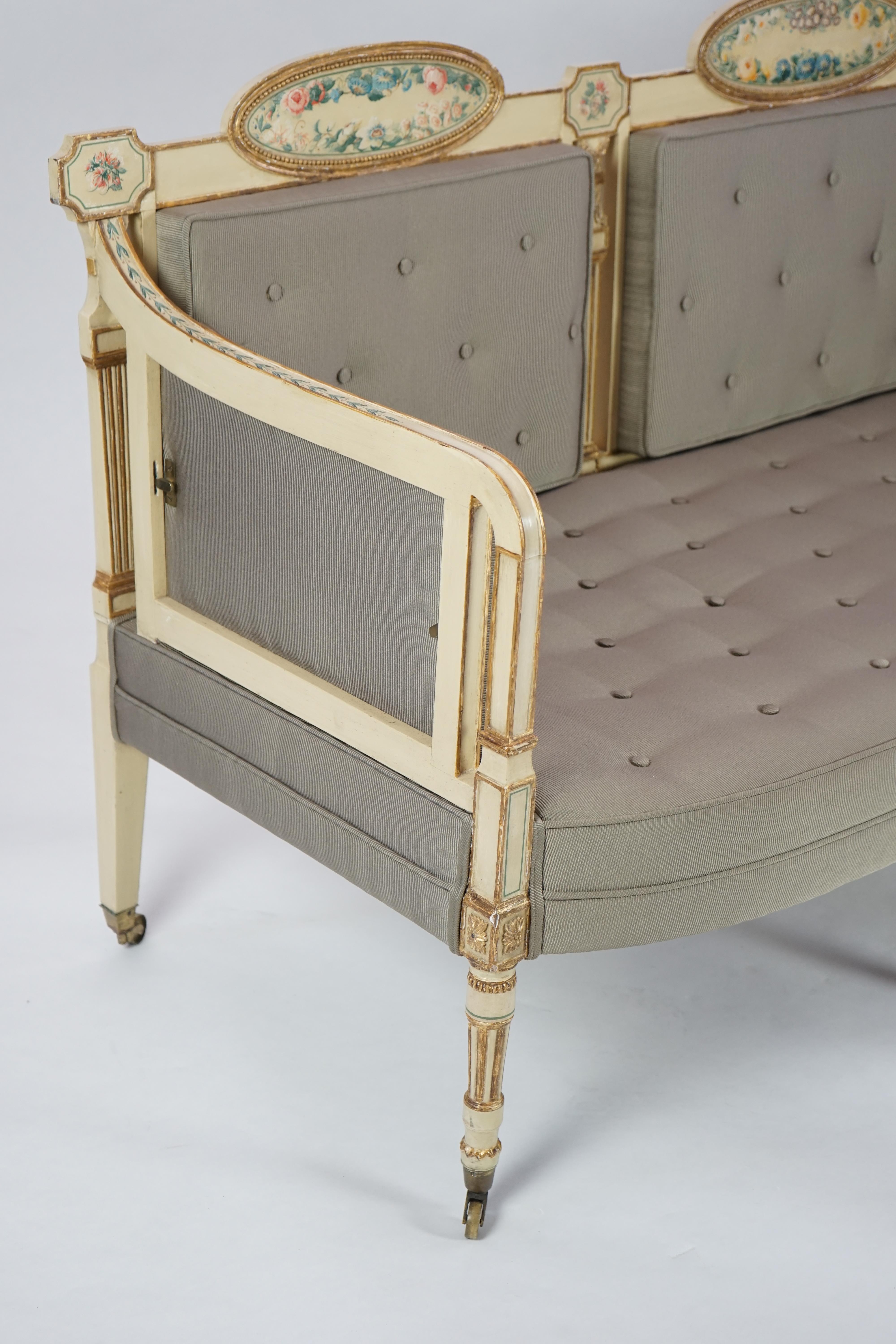 A pair of George III cream painted and parcel gilt settees, in the manner of George Brookshaw (1751-1823)